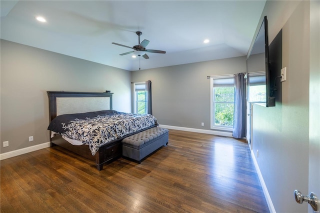 bedroom featuring multiple windows, dark hardwood / wood-style floors, and ceiling fan