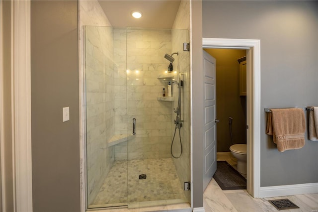 bathroom with a shower with shower door and toilet