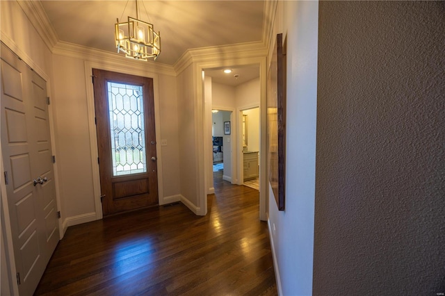 entrance foyer with dark wood-type flooring, a notable chandelier, and crown molding