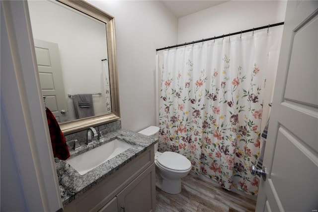 bathroom featuring vanity, hardwood / wood-style flooring, toilet, and a shower with curtain