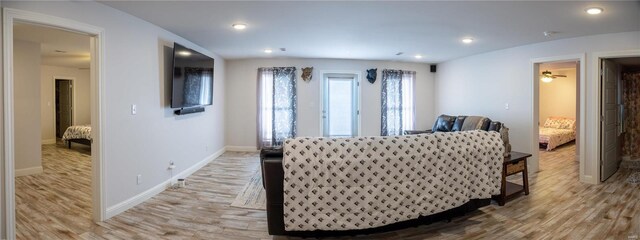 living room with light hardwood / wood-style floors and ceiling fan