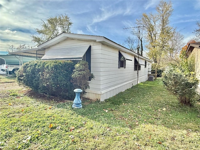 view of property exterior featuring central AC unit and a yard