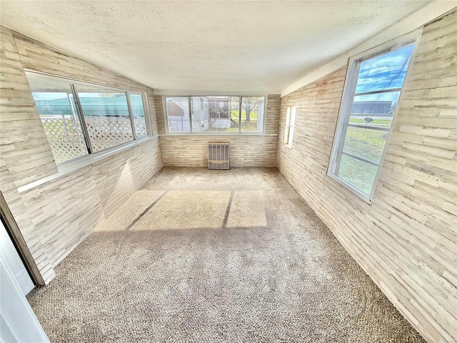 unfurnished sunroom featuring vaulted ceiling