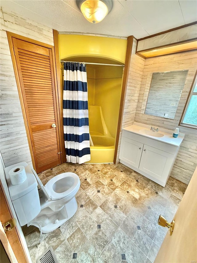 full bathroom with wood walls, shower / bath combination with curtain, toilet, and vanity