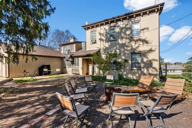 rear view of property with a fire pit and a patio area