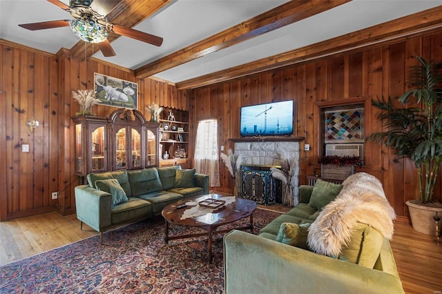 living room featuring a fireplace, wooden walls, hardwood / wood-style floors, and beamed ceiling