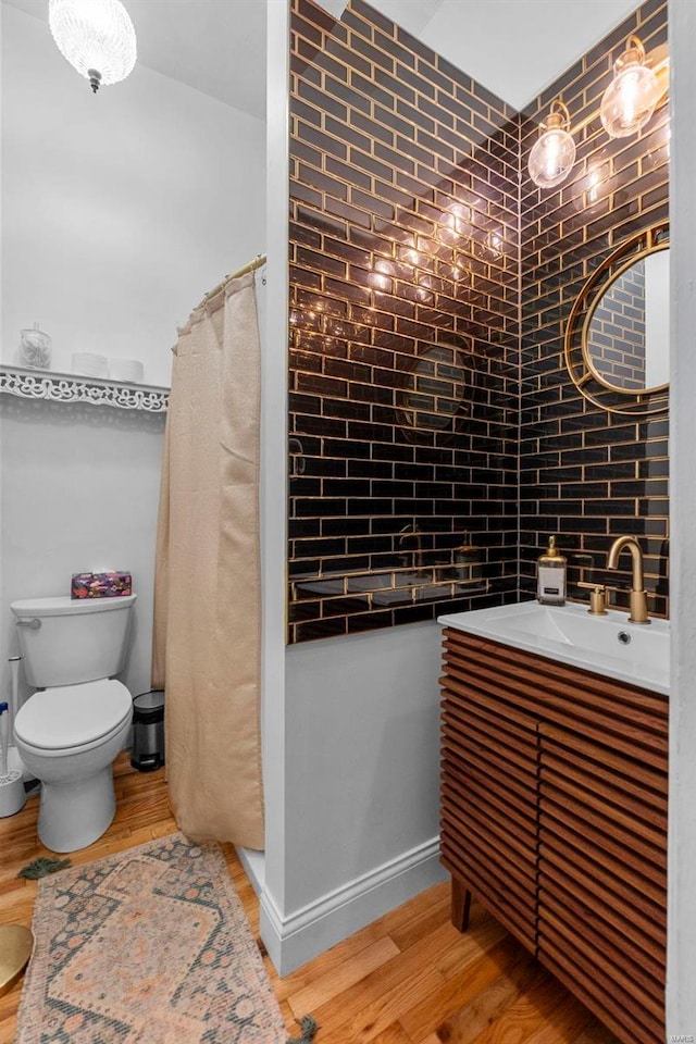 bathroom featuring tasteful backsplash, a shower with curtain, vanity, hardwood / wood-style flooring, and toilet