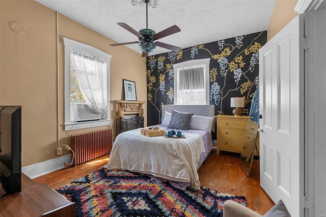 bedroom with ceiling fan, wood-type flooring, and radiator