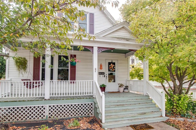 view of exterior entry featuring covered porch