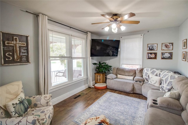 living room with dark hardwood / wood-style flooring and ceiling fan