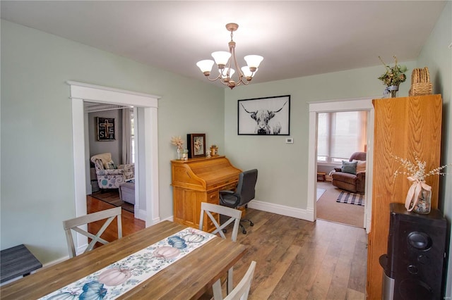 dining area featuring hardwood / wood-style flooring and a notable chandelier