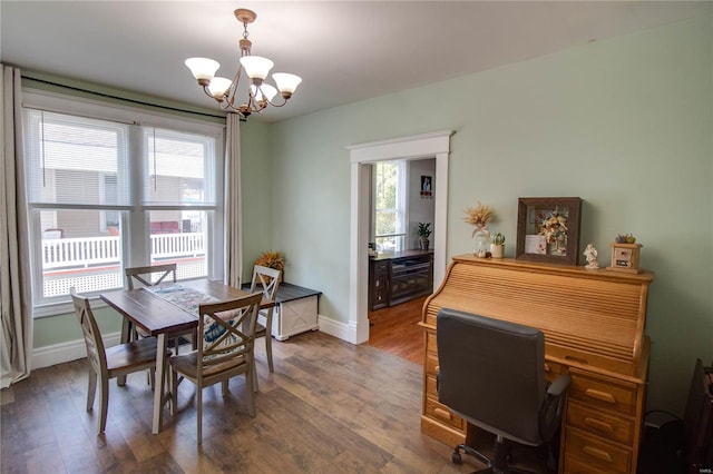 dining space with plenty of natural light, dark wood-type flooring, and an inviting chandelier