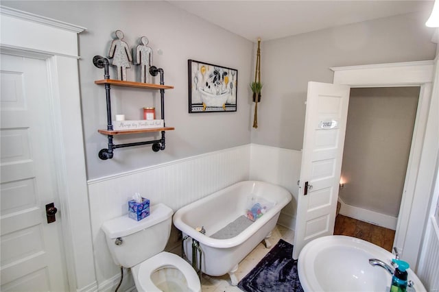 bathroom with toilet, a bath, and hardwood / wood-style floors