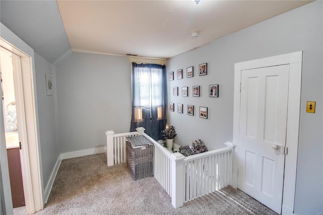 unfurnished bedroom with a nursery area, carpet floors, crown molding, and vaulted ceiling