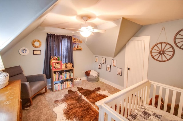 carpeted bedroom featuring a nursery area, ceiling fan, and vaulted ceiling