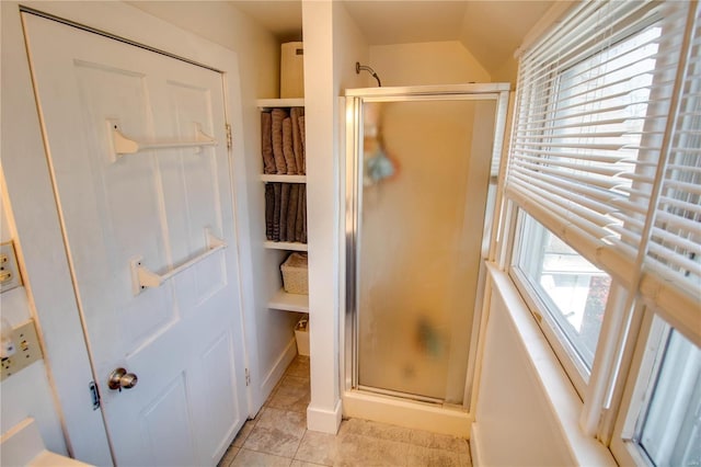 bathroom with an enclosed shower, a wealth of natural light, and tile patterned floors