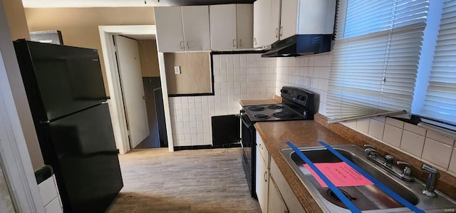 kitchen featuring sink, tasteful backsplash, white cabinetry, and black appliances