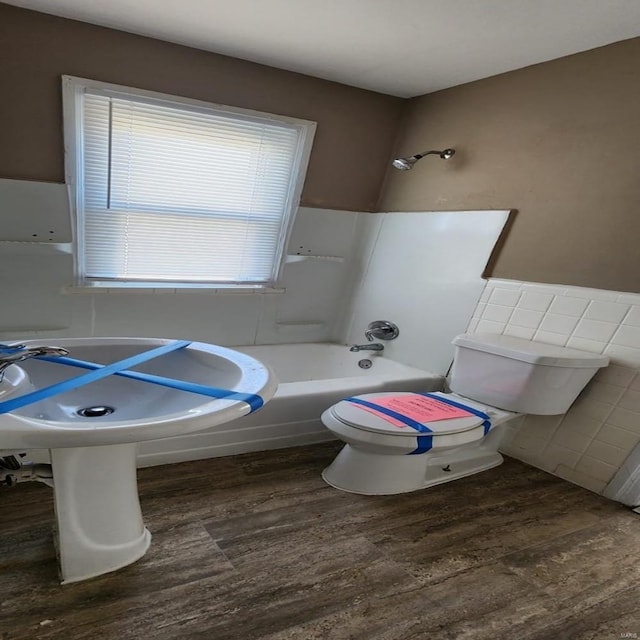 bathroom featuring shower / bathing tub combination, wood-type flooring, and toilet