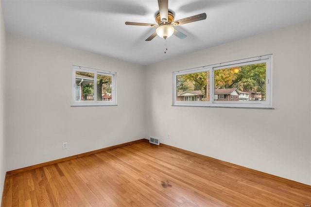 spare room with ceiling fan, wood-type flooring, and plenty of natural light