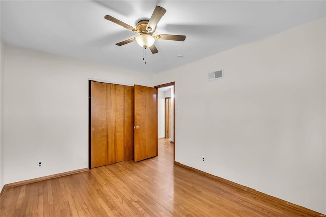 unfurnished bedroom featuring light wood-type flooring, ceiling fan, and a closet