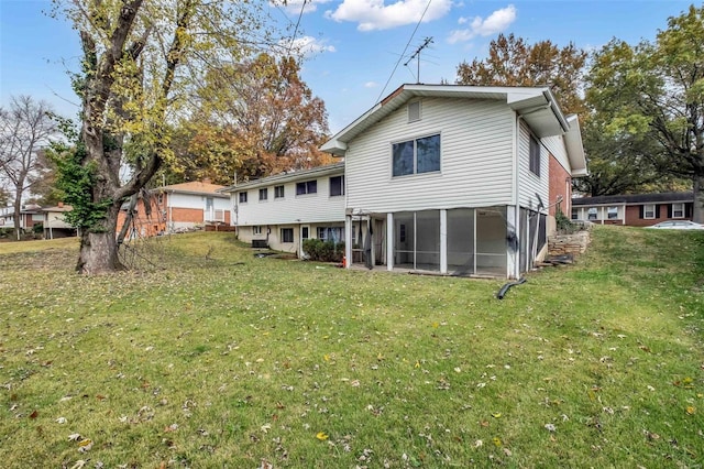 rear view of property with a sunroom and a yard