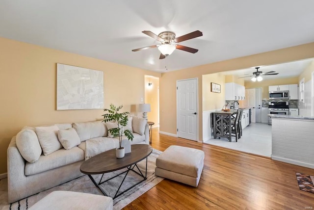 living room featuring ceiling fan and light hardwood / wood-style floors