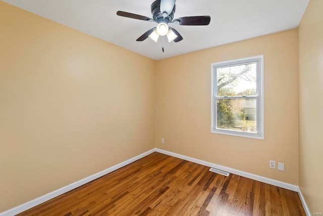 empty room with hardwood / wood-style floors and ceiling fan