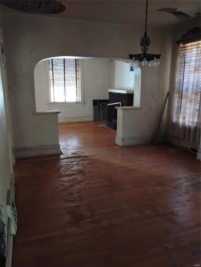 unfurnished dining area with an inviting chandelier and hardwood / wood-style floors