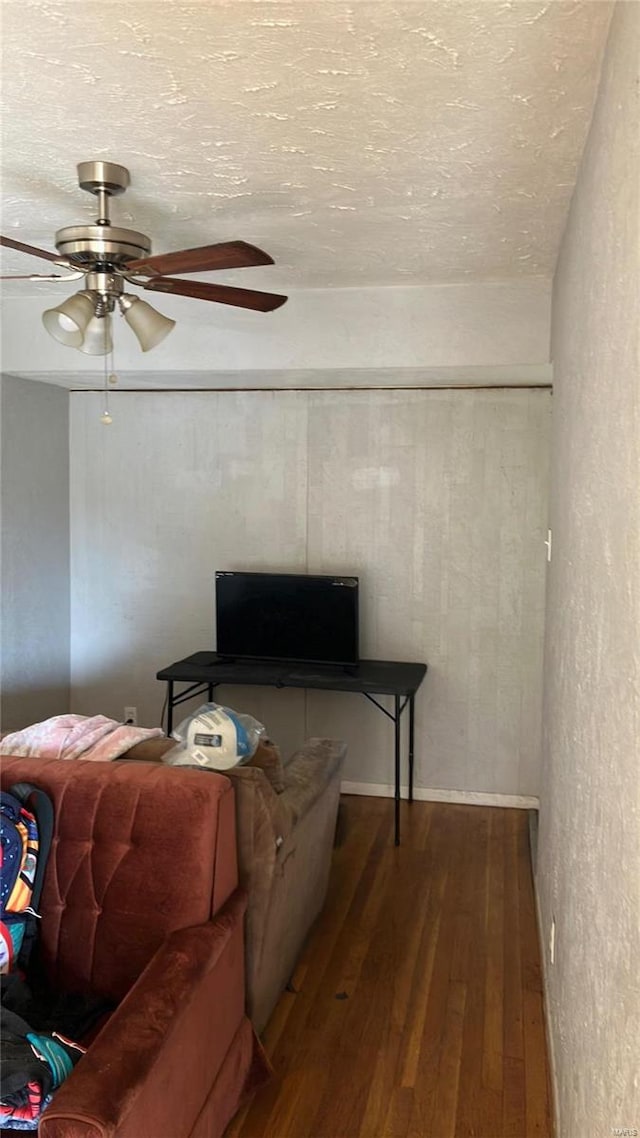 living room featuring ceiling fan and dark wood-type flooring