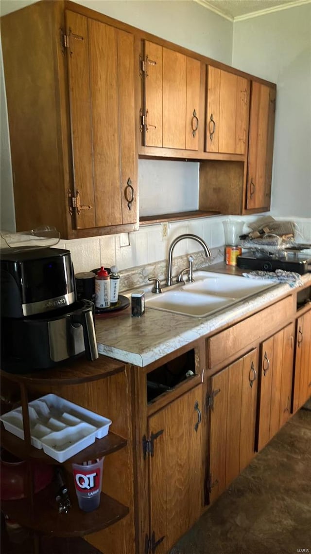 kitchen with tasteful backsplash, crown molding, and sink