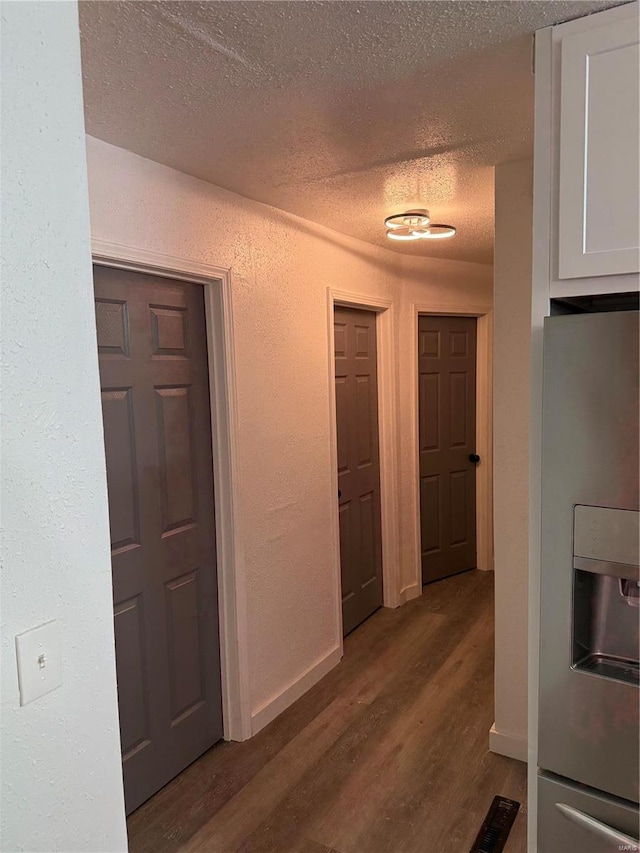 hallway featuring wood-type flooring and a textured ceiling