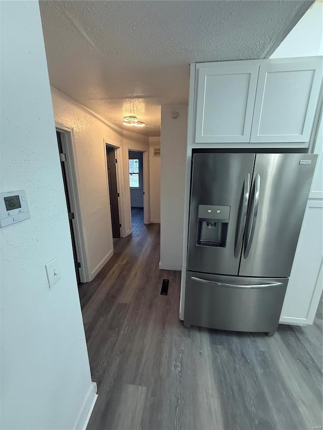 kitchen featuring white cabinets, stainless steel refrigerator with ice dispenser, a textured ceiling, and dark hardwood / wood-style floors