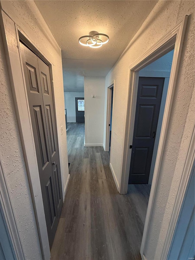 hall featuring dark hardwood / wood-style flooring and a textured ceiling