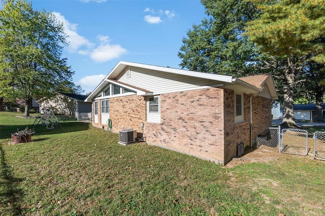 view of home's exterior featuring a lawn and central AC