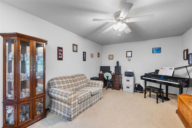 sitting room with ceiling fan, a textured ceiling, and carpet flooring