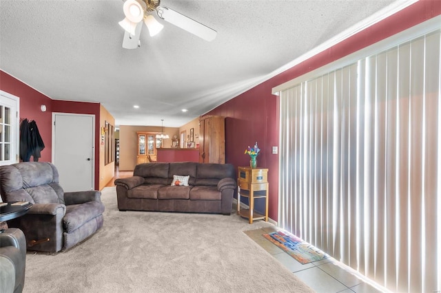 carpeted living room featuring a textured ceiling and ceiling fan