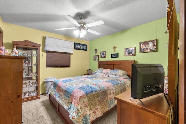 carpeted bedroom featuring ceiling fan and a textured ceiling