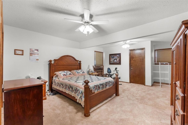 bedroom with a textured ceiling, light carpet, and ceiling fan