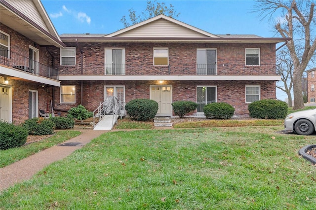 townhome / multi-family property featuring a balcony and a front lawn