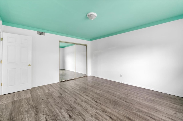 unfurnished bedroom with a closet and hardwood / wood-style flooring