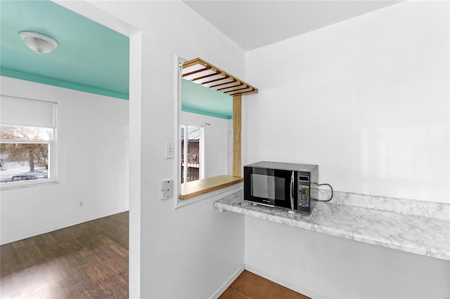 kitchen featuring light stone countertops, dark hardwood / wood-style flooring, and plenty of natural light