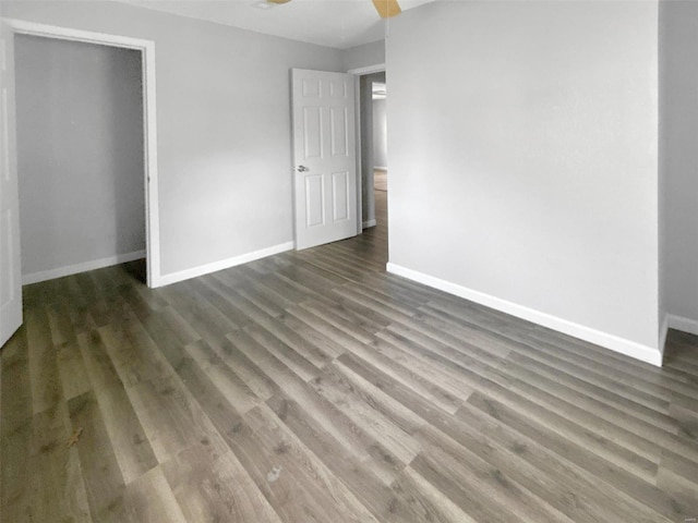 unfurnished bedroom with dark hardwood / wood-style floors, ceiling fan, and a closet