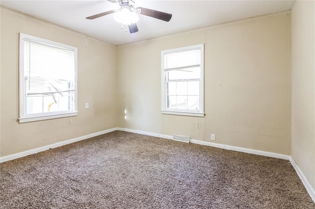 empty room with ceiling fan, a healthy amount of sunlight, and carpet floors