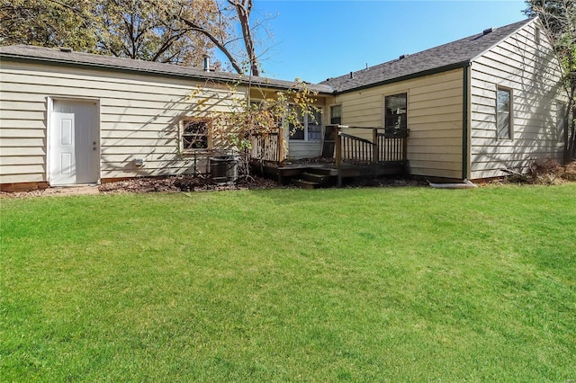 back of property with a wooden deck and a lawn