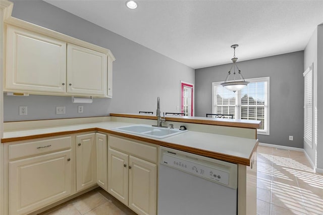 kitchen featuring cream cabinets, sink, white dishwasher, and kitchen peninsula