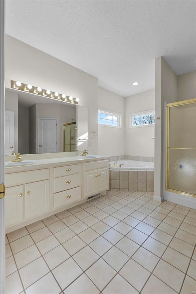 bathroom with plus walk in shower, tile patterned floors, a textured ceiling, and vanity