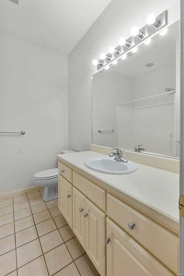 bathroom featuring vanity, tile patterned floors, and toilet