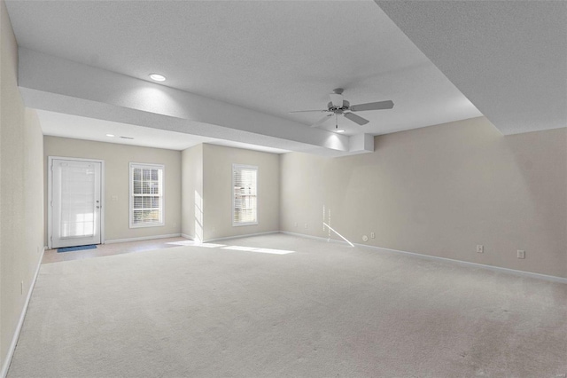 spare room with light colored carpet, a textured ceiling, and ceiling fan