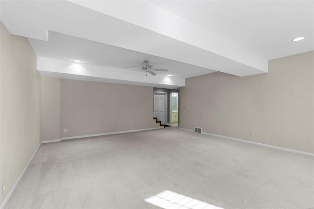 basement with ceiling fan and light carpet