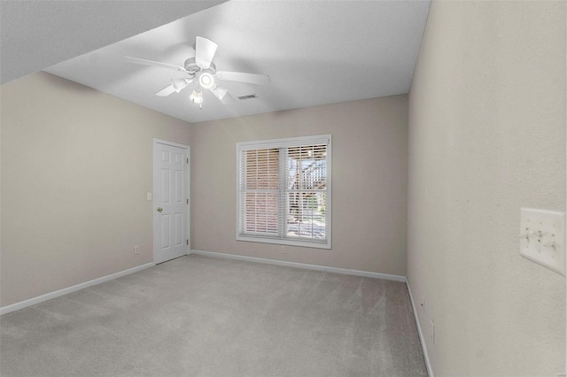 spare room featuring light carpet and ceiling fan